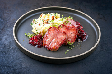 Traditional fried cured and sliced veal tongue with mashed potatoes and cranberries relish offered...
