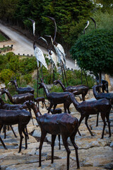 Lisbon, Portugal: 09/08/2020: Hiding part of the Buddha Garden with the african and wild animals sculptures (crocodile, giraffe, snake, monkey) in brass material. Buddha Eden, asian style garden.