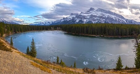 Panoramic Landscape View across Frozen Johnson Lake to Rundle Mountain Range near Banff in Canadian Rockies