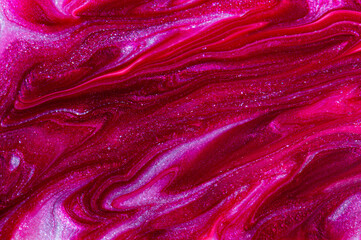 Abstract sparkling purple red background. Close up of nail polish texture. Soft focus.