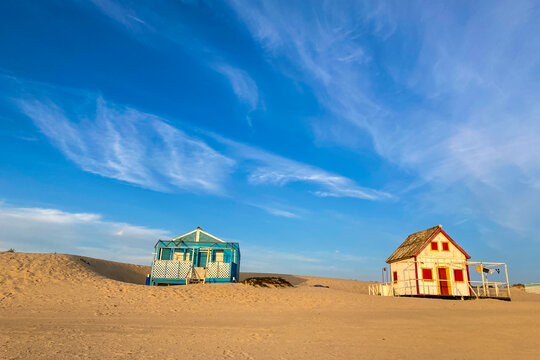 Beautiful characteristic wooden house along the beach side at Costa da Caparica in Lisbon, Portugal. Small village on the beach at sunset facing the Atlantic Ocean, abandoned building on the beach