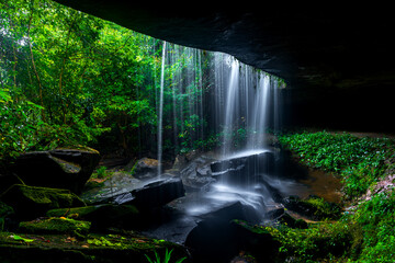 A small waterfall in the deep forest of the border of Thailand and Cambodia,ASIA.Khun Sri waterfall in tropical forest,Sisaket province,Thailand. Leaf moving low speed shutter blur.