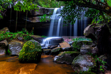 A small waterfall in the deep forest of the border of Thailand and Cambodia,ASIA.Khun Sri waterfall in tropical forest,Sisaket province,Thailand. Leaf moving low speed shutter blur.