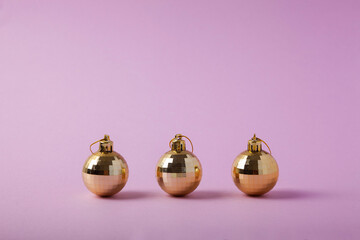 Gold Christmas decorations on a pink background.Christmas, winter holiday, new year concept.