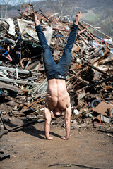 Young Athletic Man Doing Handstand at Industrial Junkyard