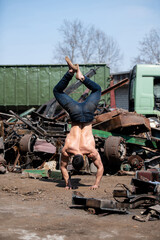 Young Athletic Man Doing Handstand at Industrial Junkyard
