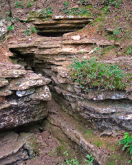 A crevice creeps up the side of the mountain at Devils Den state park. - obrazy, fototapety, plakaty