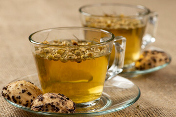 two cups of chamomile tea with sweet wafer