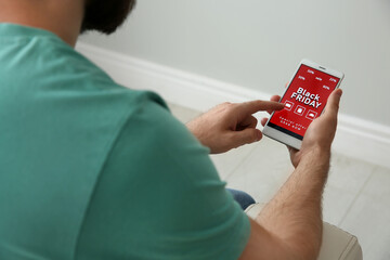 Man shopping online using smartphone at home, closeup. Black Friday Sale