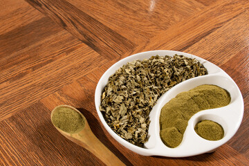 Moringa powder in wooden spoon - dried moringa leaves - moringa oleifera.