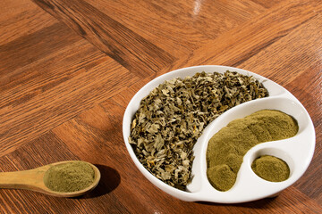 Moringa powder in wooden spoon - dried moringa leaves - moringa oleifera.