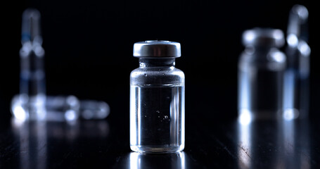 Medical syringe with a needle and a bollte with vaccine.