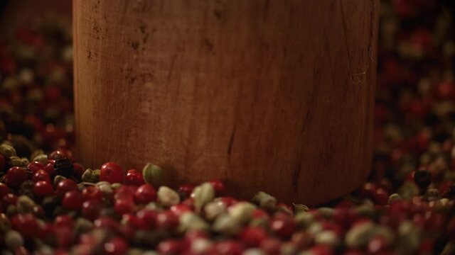 Spices are being crushed in a wood mortar in slow motion. Concept of healthy and organic food, herbal medicine, natural care, aromatherapy and organic cosmetics.Slow motion 900 fps video.