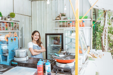 young food stall owner smiling to camera while standing on her truck container shop