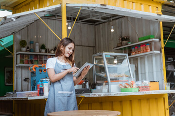 beautiful woman taking online order at her small stall shop. young small business owner