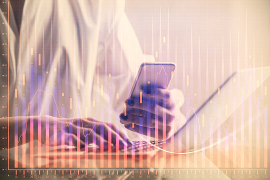 Double exposure of financial graph sketch hologram and woman holding and using a mobile device. Stock exchange concept.