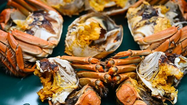 side view opened crabs showing the crab roe and meat turning