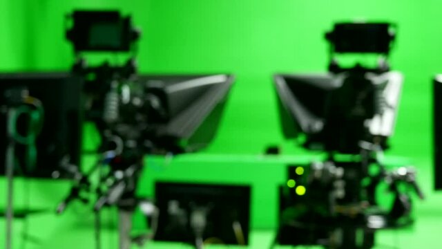 abstract blurred of broadcast camera in studio with virtual greenscreen at TV station