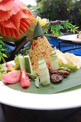 Traditional Indonesian Cuisine Nasi Tumpeng. Tumpeng is a cone-shaped rice dish like mountain with meats usually eat as breakfast or lunch