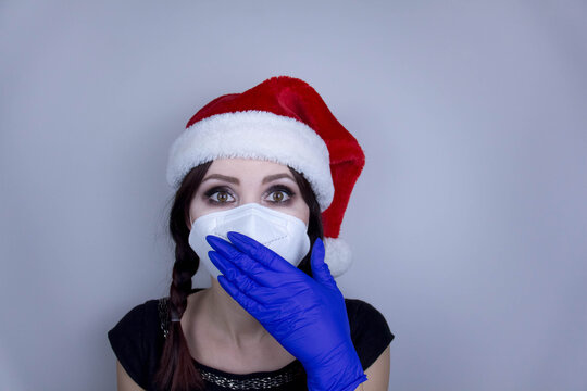 Woman wearing protection face mask against coronavirus. Woman in a mask and Christmas hat. Funny Christmas accessory. Medical mask, Close up shot, Select focus, Prevention from covid19