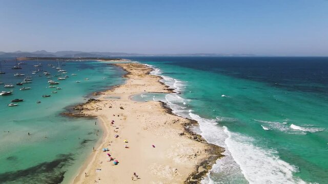 Incredibly beautiful beach on the Formentera island. Many unrecognizable people are relaxing on the beach on the island