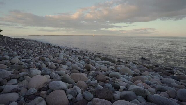 Rocky Beach  and  sailor boat at sunset.