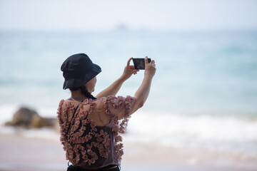 Asian woman in floral blouse taking selfies