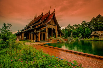 The background of the Wat Pa Kham Charoen is a beautiful old church with a Buddhist statue and a tree-lined temple, with tourists and travelers always making merit in Udon Thani, Thailand.