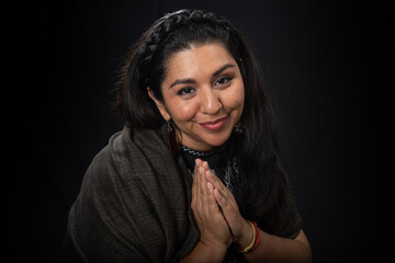 
Mujer latina con cabello negro ojos expresivos y sonriente con hermosa sonrisa, sobre fondo negro, viste ropa étnica y mantón negro, sanadora y sanadora mexicana