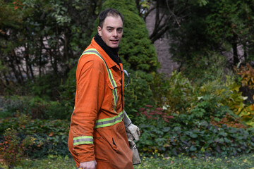 Specialized worker walking in the street after work and looking at the camera