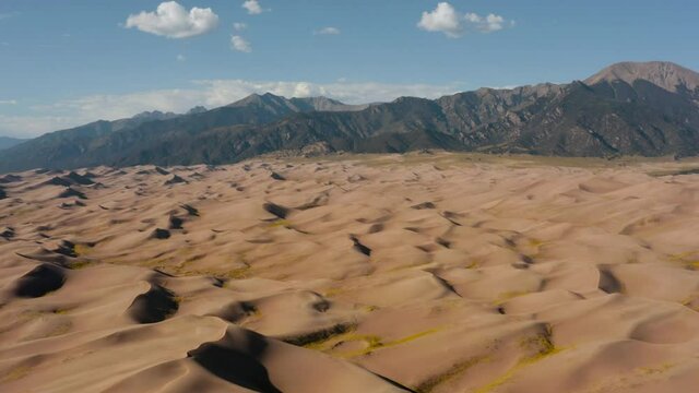 Aerial view flying over sandbanks, approaching the North Zapata mountain ridge, in the Great sand dunes national park - tilt up, drone shot