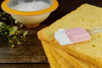 Sliced pound cake and cream. Preparation for making festive cake.