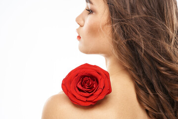 Naklejka premium Woman with naked shoulders and red rose evening makeup light background
