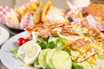 A closeup view of a chicken salad among other lunch entrees.