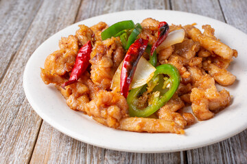 A view of a plate of hot and spicy chicken, in a restaurant or kitchen setting.