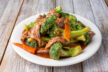 A view of a plate of beef broccoli, in a restaurant or kitchen setting.