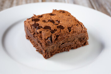 A closeup view of a chocolate chip brownie on a plate.