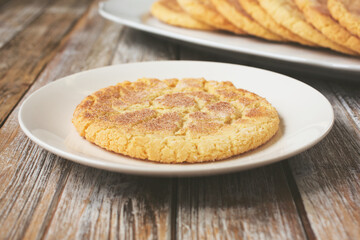 A view of a sugar cookie on a saucer, in a restaurant or kitchen setting.