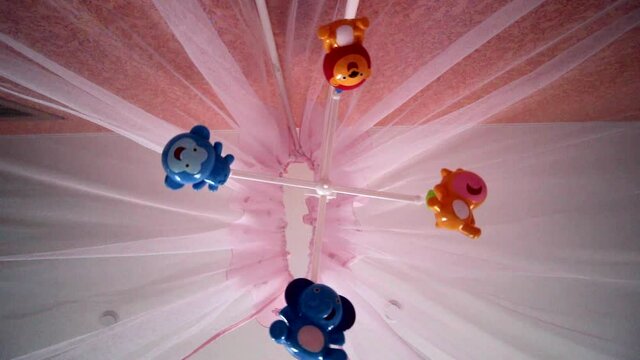 Musical baby rotating toy hangs above the crib.