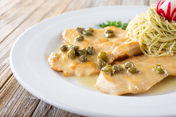 A view of a plate of chicken piccata.