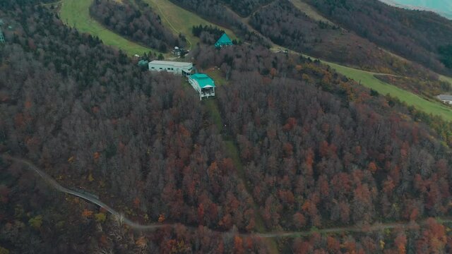 View From Above Of Colorful Forest In Fall Colors And Cable Car Station On A Mountain In Zao Onsen, Japan - aerial