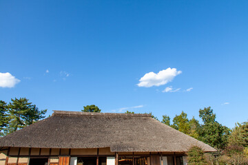 Fototapeta na wymiar Japanese Thatched Roof House against the Blue Sky