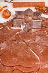 Cookie cutters in shape of star on dough for baking gingerbread or Christmas cookies