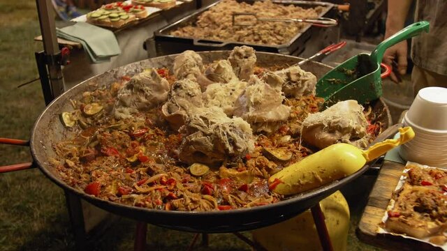 Cooking cabbage with meat and vegetables in a cauldron. Turkey knuckles. Bigos, a traditional dish from Poland. Fast food, outside. Festival of flavors. Fest.