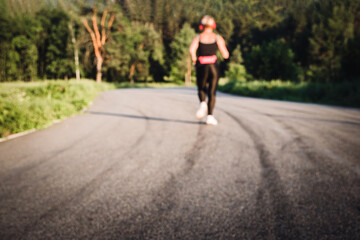 Blurred back view of jogging senior woman silhouette running on a road outdoor. Out of focus background. Real life moments. Back view. Copy space.