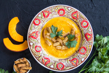Delicious healthy pumpkin soup, herbs, and ingredients for the dish. Creative atmospheric decoration