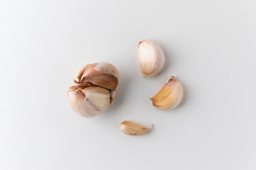 Garlic cloves and pieces of raw garlic on isolated white background. Top view Garlic bulbs.
