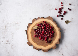 fresh cranberries on a wooden stump on a  light background