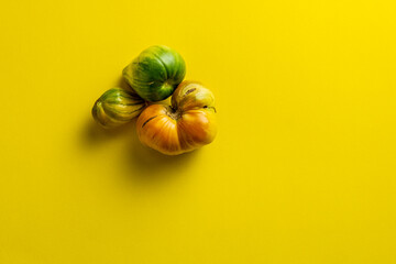 groop of green tomatos isolated over the yellow background top view.