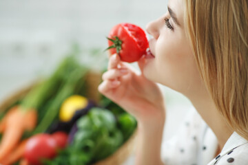 Beautiful young woman eating vegetables in the kitchen. Healthy food. Vegan salad. Diet. Diet concept. Healthy lifestyle. Cook at home. High quality photo.